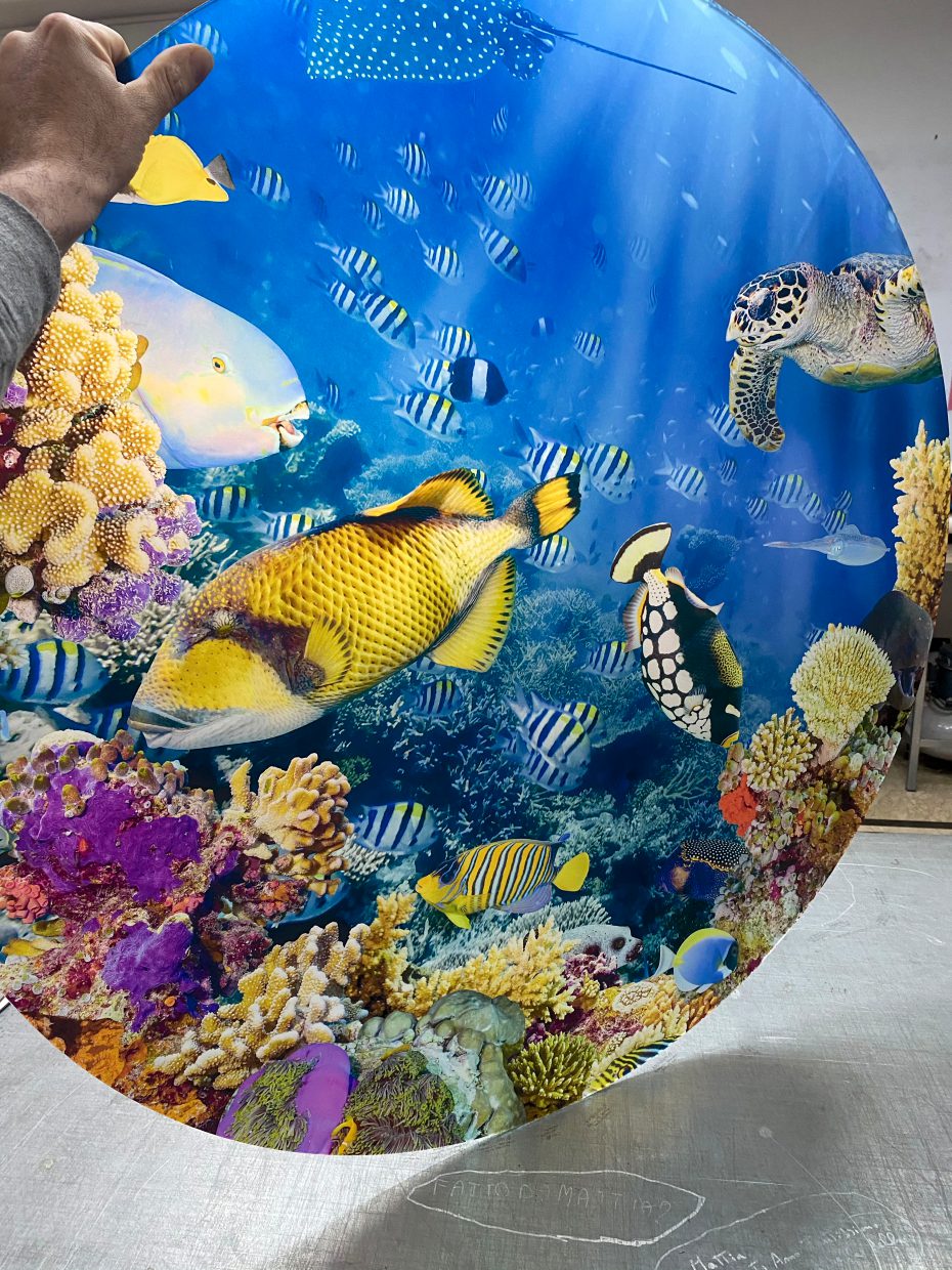 Pellicola adesiva con grafica di fondale marino applicata a un pannello in lavorazione